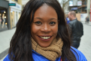 Photo of a young lady smiling on a city street